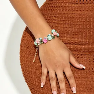 Pulsera floral con rosas de esmalte de colores y perlas en la muñeca de la modelo