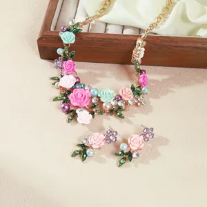 Vista detallada del conjunto de collar de flores de esmalte y perlas con pendientes a juego.