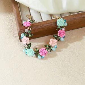 Vista detallada de una pulsera floral elegante con rosas en tonos pastel y perlas.