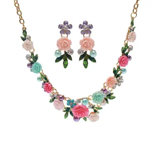 Vista detallada del juego de joyas de flores esmaltadas con perlas y cristales de colores.