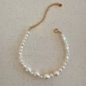 Détail d'un collier de perles d'eau douce irrégulières avec chaîne dorée