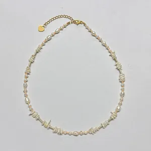 Vue détaillée d'un collier de perles d'eau douce fait main avec pendentif cœur doré