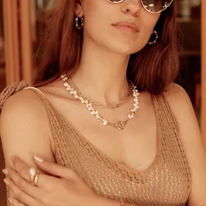 Gros plan d'un collier doré à deux rangs avec de belles perles d'eau douce irrégulières