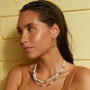 Gros plan d'un modèle portant un collier double rang en perles d'eau douce irrégulières