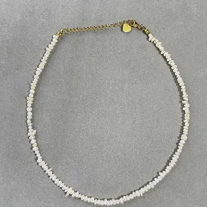 Vue détaillée du collier en perles d'eau douce irrégulières avec fermoir cœur doré