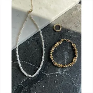 Collier élégant en perles d'eau douce naturelles et bracelet en perles dorées sur marbre