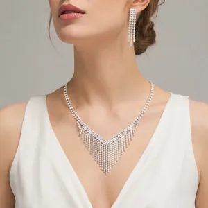Detailed view of luxury bridal crystal fringe necklace and matching drop earrings on a model