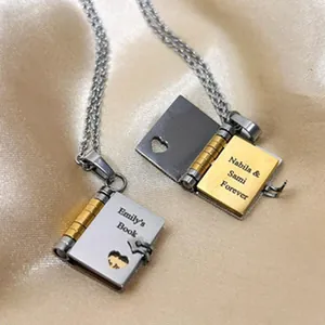 Detail of book-shaped locket necklace showing personalized engraving and open feature.