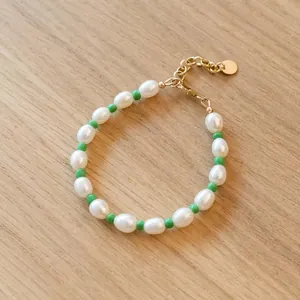 Vue rapprochée d'un bracelet artisanal en perles baroques d'eau douce et rocailles vertes