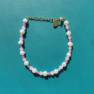 Détail d'un bracelet en perles baroques fait main avec perles colorées et breloque cœur