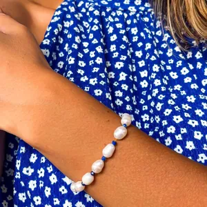 Gros plan d'un bracelet fait main en perles d'eau douce baroques avec perles bleues
