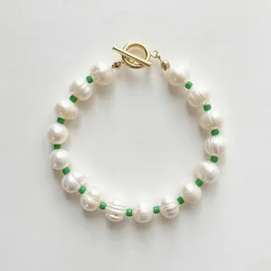 Gros plan du bracelet artisanal en perles de culture baroques avec perles vertes