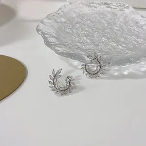 Primo piano di eleganti orecchini a foglia in argento con cristalli scintillanti