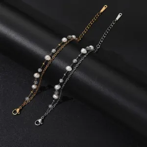 Primer plano de pulseras de acero inoxidable con perlas de agua dulce y ágata