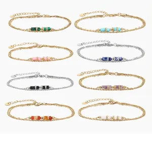 Detalle de ocho pulseras de piedras semipreciosas en acero inoxidable tono oro y plata