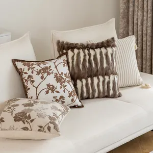 Elegant French chic decorative cushion covers with floral and faux fur designs on couch