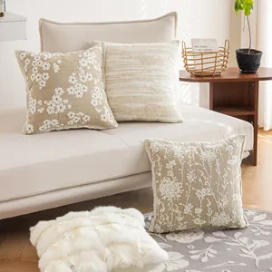 French style floral and textured cushion covers on a beige sofa in a cozy living room
