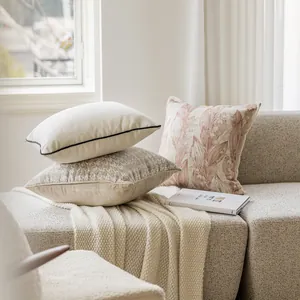 Detailed view of light French floral and textured cushion covers on a modern cozy sofa