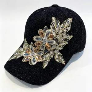 Dettaglio del ricamo floreale con strass su cappello da baseball invernale nero