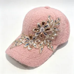 Dettaglio di cappello da baseball rosa peloso con fiori in pizzo e strass