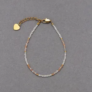 Macro detail of bohemian natural stone beaded bracelet with gold heart charm