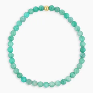 Close-up of bohemian green natural stone beaded bracelet with a single gold bead accent