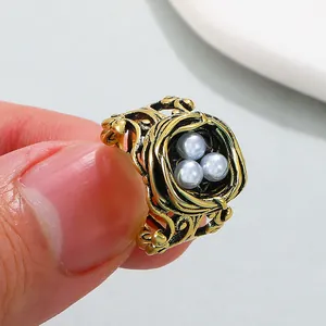Vintage antique gold bird's nest ring featuring three light blue pearls for women