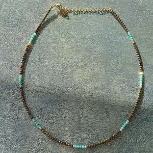 Vue détaillée d'un collier fait main avec des perles d'oeil de tigre brun et turquoise