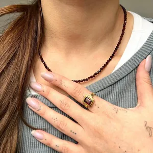 Vue détaillée d'un collier de perles en pierre naturelle grise avec bague dorée
