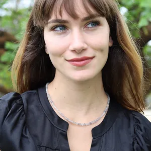 Gros plan d'une femme portant un collier de perles en pierre naturelle grise phosphore