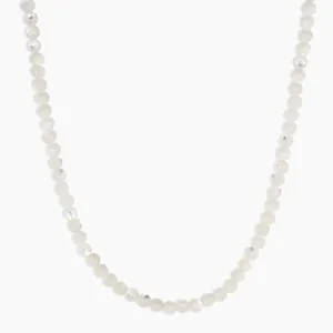 Gros plan d'un collier en perles de pierre naturelle grise à la texture lisse et brillante.