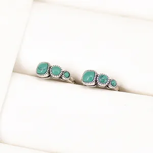 Close-up of vintage S925 silver earrings with turquoise stones in a white jewelry box.