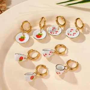 Detailed view of ceramic hoop earrings featuring miniature strawberry and cherry patterns.