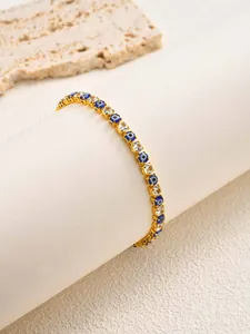 Close-up of golden evil eye bracelet with clear zirconia stones on display stand