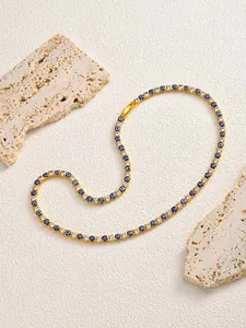 Detailed view of a gold-toned hip hop bracelet with evil eye and clear zircon stones.