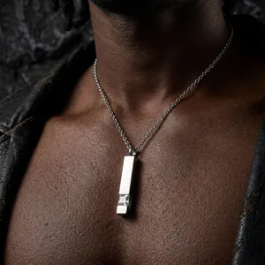 Close-up of a polished stainless steel bar pendant necklace with inset square crystal