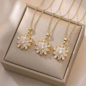 Close-up of three gold flower necklaces with sparkling zircon pendants on a jewelry box.