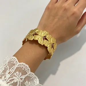 Detailansicht eines hochwertigen vergoldeten Edelstahl-Armreifs mit floralem Muster.