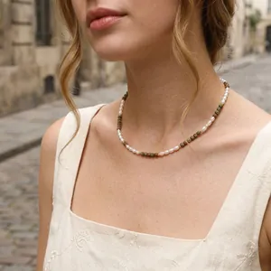 Close-up of vintage freshwater pearl and green stone necklace worn on a model.