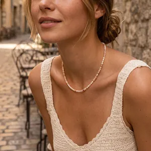 Professional detail view of a pink opal and freshwater pearl beaded necklace on a female model