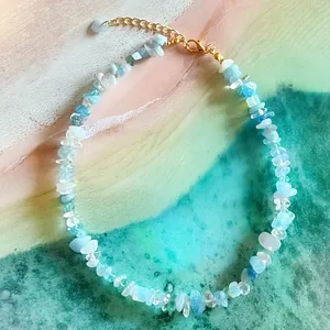 Vue détaillée d'un collier ras du cou en pierres bleues irrégulières style plage et fermoir doré