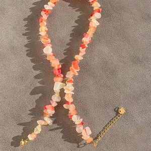 Gros plan d'un collier de plage avec des perles de pierre orange semi-transparentes