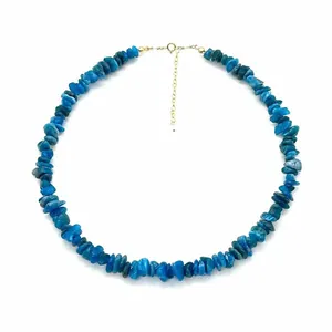 Gros plan détaillé d'un collier de pierres naturelles bleues avec chaîne dorée réglable