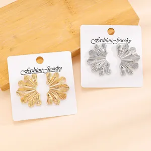 Close-up of vintage leaf design earrings in gold and silver finishes on display cards