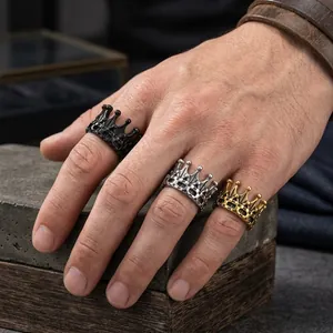 Detailed close-up showing Gothic crown rings in black silver and gold finishes on a hand