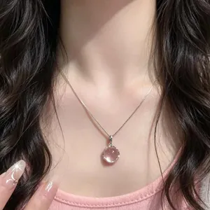 Gros plan d'un élégant collier avec pendentif en calcédoine rose sur un modèle