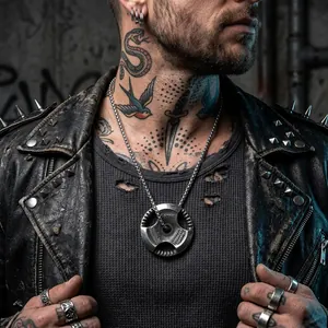 Detail view of a vintage dumbbell plate pendant necklace on a tattooed male model.