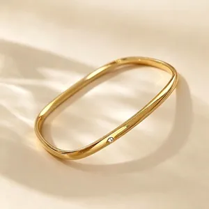 Nahaufnahme eines minimalistischen vergoldeten quadratischen Edelstahlrings mit kleinem Stein.