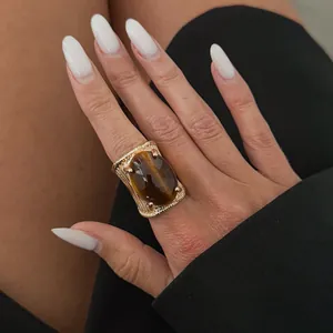 Λεπτομερές κοντινό πλάνο χρυσού ριγέ δαχτυλιδιού με οβάλ κεχριμπαρένια πέτρα από ρητίνη