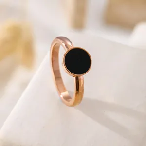 Macro di un anello minimalista in oro rosa con un intarsio circolare in conchiglia nera